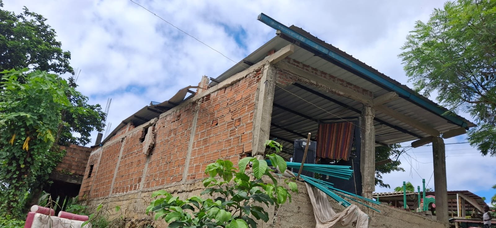 Fachada en ladrillo con el techo desprendido en una esquina