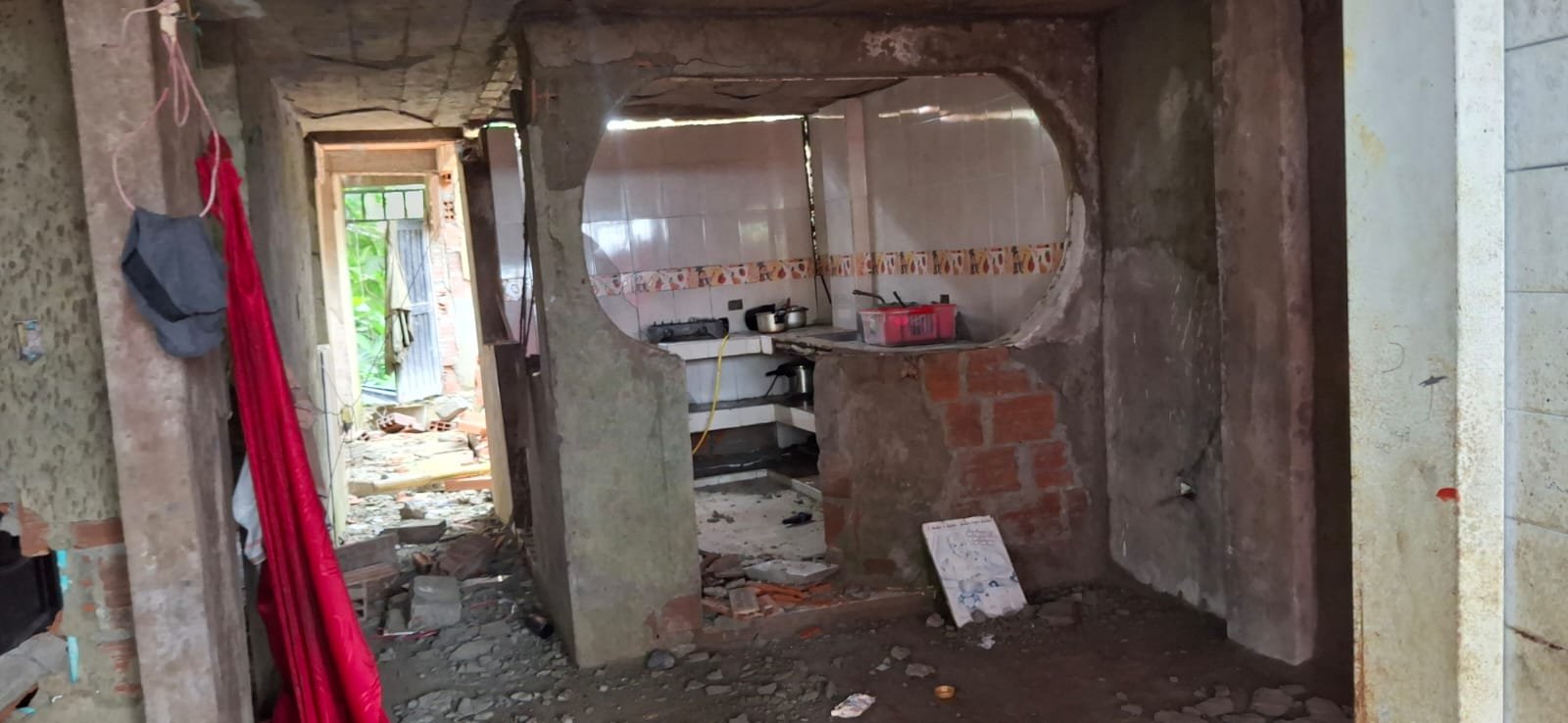 Cocina con grietas junto a escombros de la pared caída