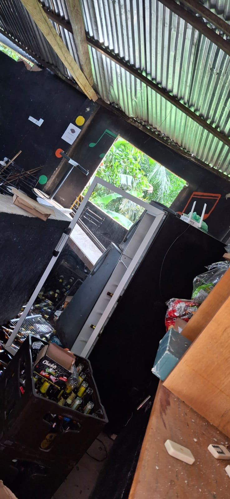 Interior de un negocio con estantería y puerta hacia el patio