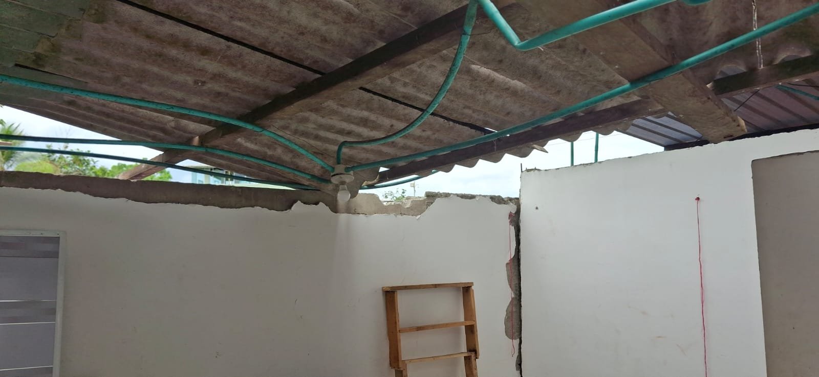Muro exterior fracturado, con varillas y cables expuestos