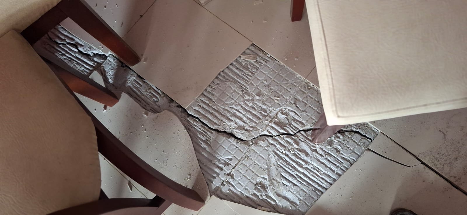Baldosas del piso levantadas y fracturadas por el sismo