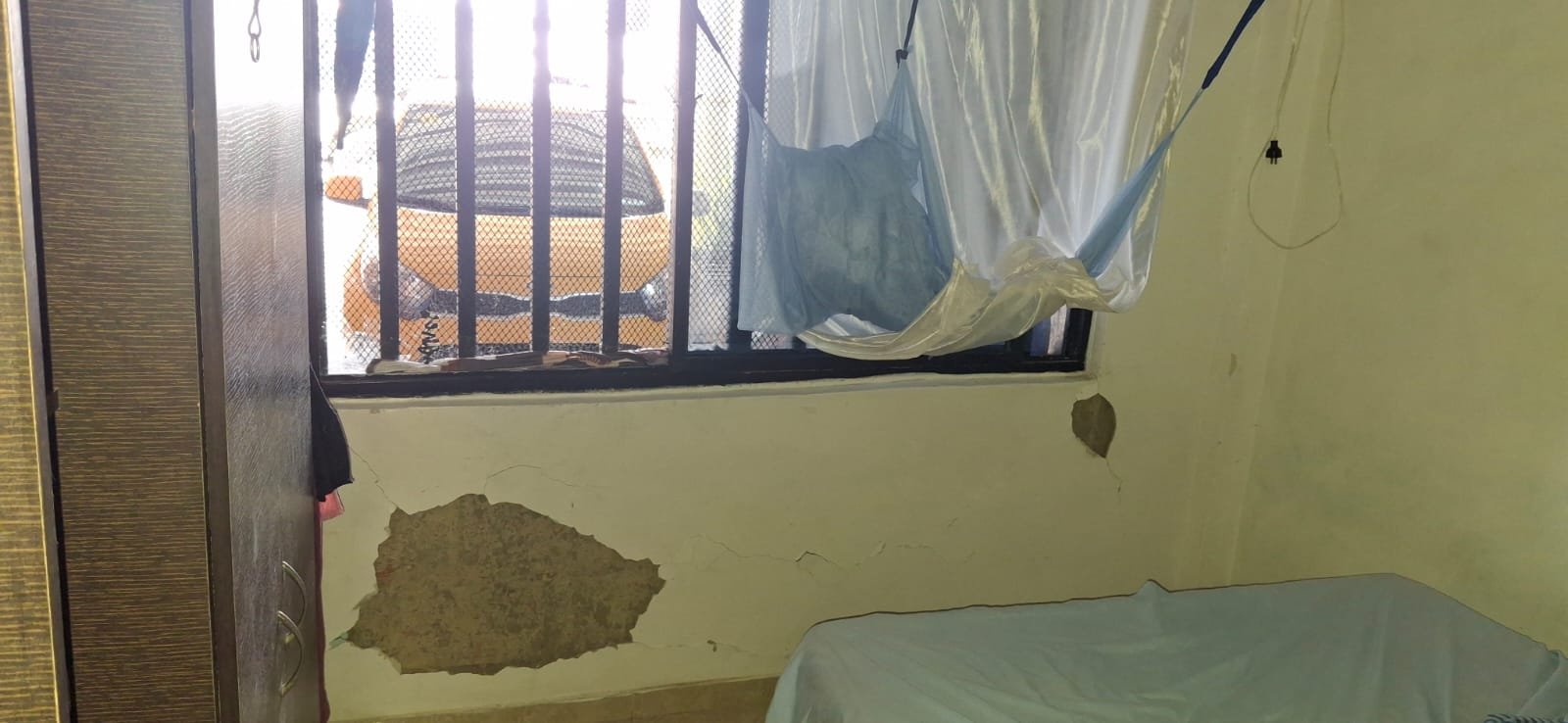 Grietas y desprendimientos en la pared junto a la ventana